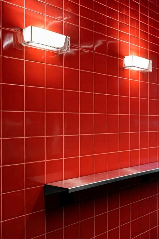 глянцевая красная плитка контрастирует с салатово-зеленой стойкой в ​​новом баре spazio maiocchi в милане